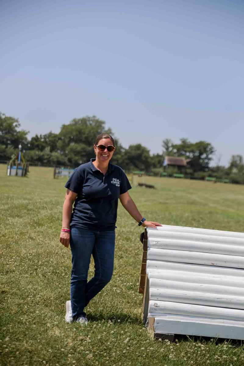 Gérante du Pôle du Cheval et de l'âne, appuyée sur un obstacle de cross lors de la visite de nos labellisés EquuRES